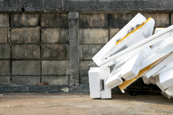 Çöpün yanında beyaz polistiren köpük. Polistiren köpük ambalaj malzemesi, el işi uygulamaları ve diğer malzemeler için yastık malzemesidir. Zararlı atık. ortamı kaydet