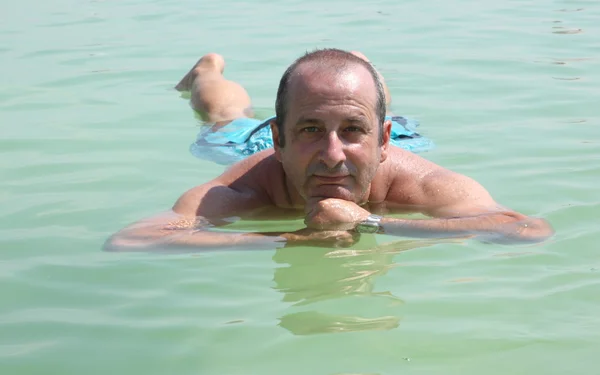 Os homens relaxam na superfície do Mar Morto — Fotografia de Stock