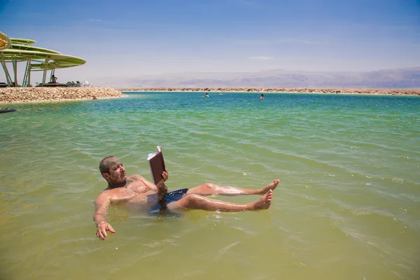 Homem flutuando e lê um livro — Fotografia de Stock