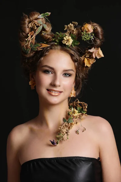 花の創造的な髪のスタイルのデザインを持つ美しい女の子 黒の背景に撮影スタジオ — ストック写真