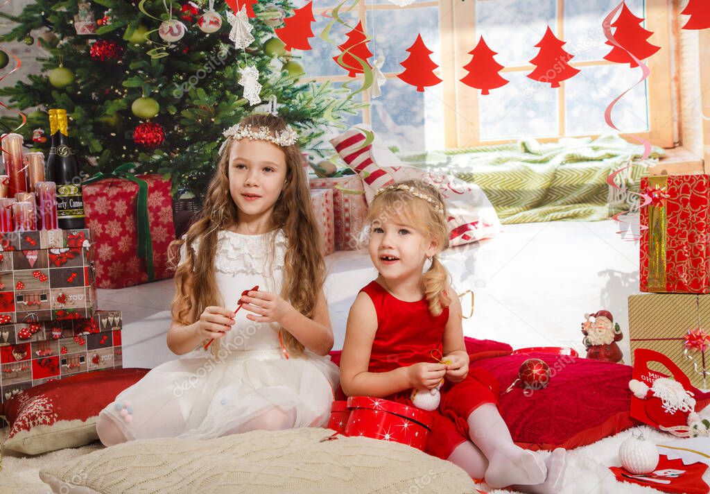 Christmas or New Year Scene. Beautiful girls sisters in Christmas interior