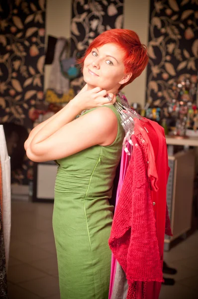 Jovem mulher escolhendo vestido — Fotografia de Stock