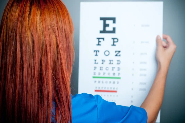 Un medico che guarda un test per l'esame oculistico — Foto Stock