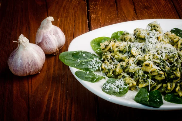 Pasta with spinach on a wooden table — Stock Photo, Image