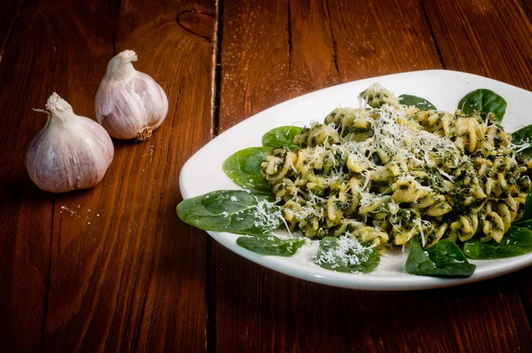 Pasta with spinach on a wooden table — Stock Photo, Image