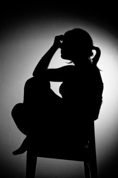 Smutna kobieta siedzi sama w pustym pokoju - biało-czarny — Zdjęcie stockowe