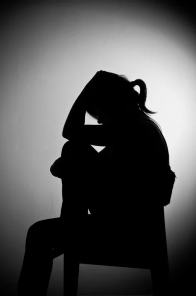 Sad woman sitting alone in a empty room - black and white — Stock Photo, Image