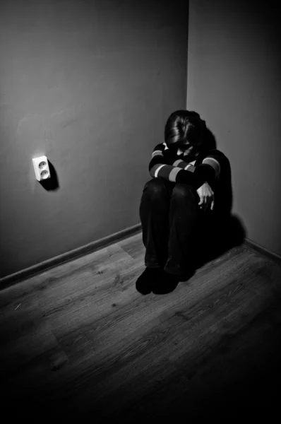 Sad woman sitting alone in a empty room - black and white — Stock Photo, Image