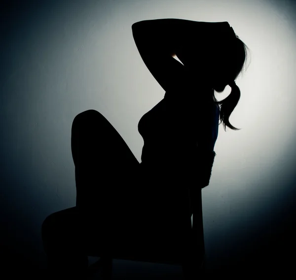 Грустная женщина сидит одна в пустой комнате — стоковое фото