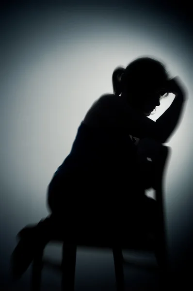 Sad woman sitting alone in a empty room — Stock Photo, Image