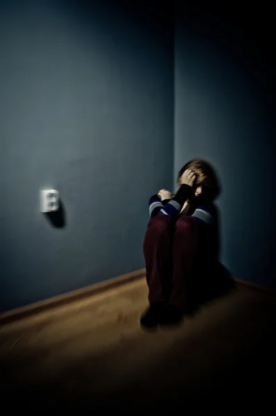 Sad woman sitting alone in a empty room — Stock Photo, Image