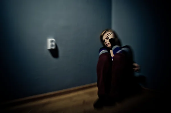 Sad woman sitting alone in a empty room — Stock Photo, Image