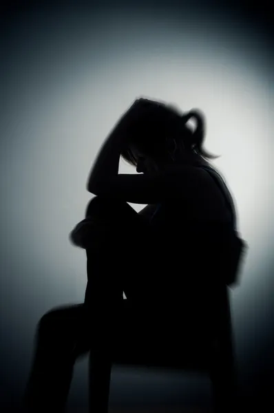 Sad woman sitting alone in a empty room — Stock Photo, Image