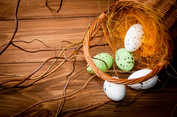 Easter eggs in nest on rustic wooden planks — Stock Photo, Image