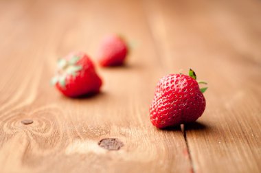 Tahta arka planda taze çilekler.