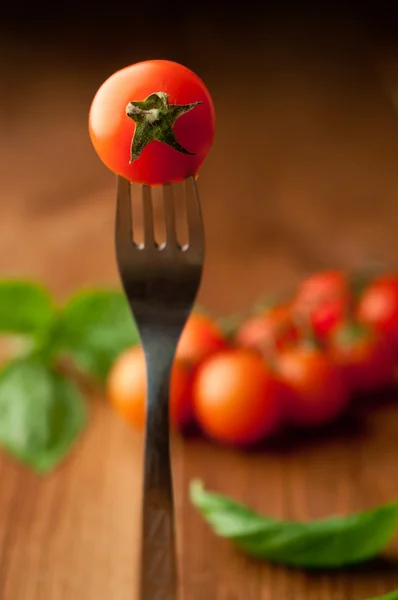 Closeup photo of fork with tomato on retro background — Stock Photo, Image