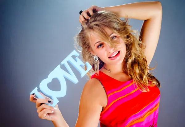 The beautiful woman in hands shows a word love — Stock Photo, Image