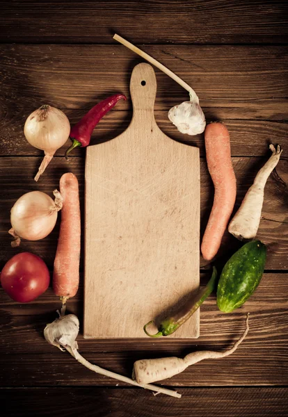 Vegetables and spices near empty cutting board — Stock Photo, Image