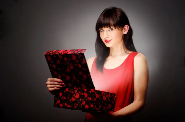 Beautiful brunette opens gift — Stock Photo, Image
