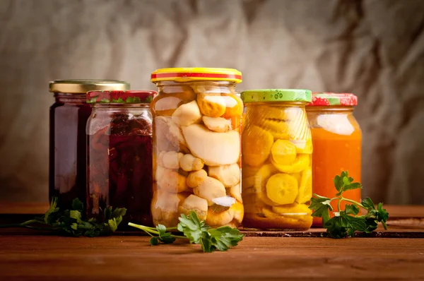 Composition with jars of pickled vegetables. Marinated food.