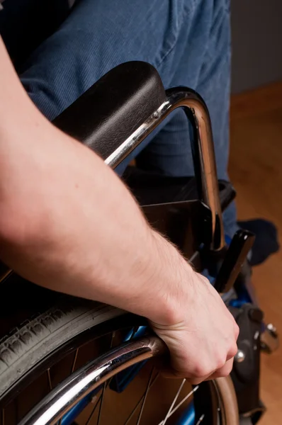 Close-up of male hand on wheel of wheelchair — Stock Photo, Image