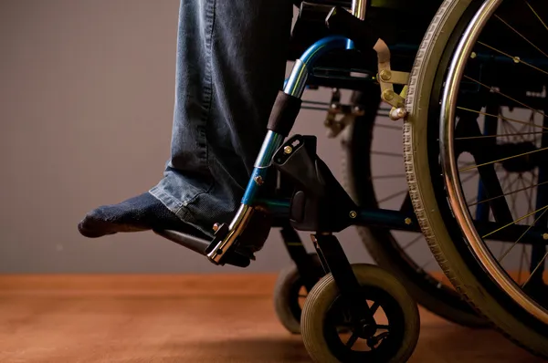 Primer plano de la mano masculina sobre el volante de la silla de ruedas — Foto de Stock