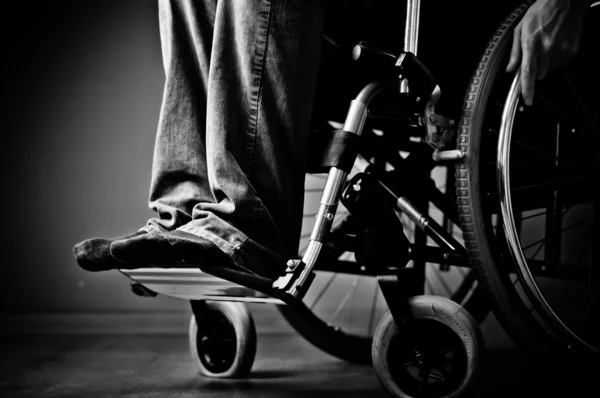 Close-up of male hand on wheel of wheelchair - blac and white — Stock Photo, Image