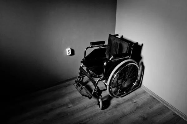 Closeup empty wheelchair on dark background and shadow in empty — Stock Photo, Image