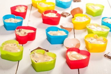 kekler hazırlamak. muffins beyaz boa üzerinde renkli silikon kalıplar içinde