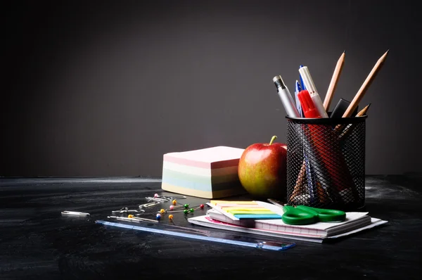 School supplies on the background of blackboard — Stock Photo, Image