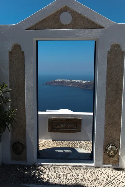 Skrze dveře směrem k oceánu, na ostrově santorini — Stock fotografie