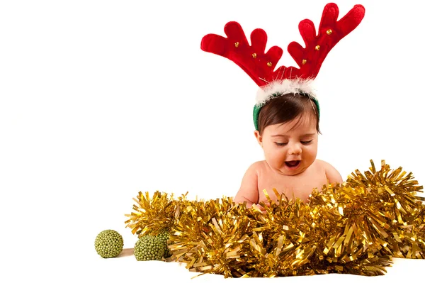 Bebê com vestido de boca aberta como rena olhando para ouropel dourado — Fotografia de Stock