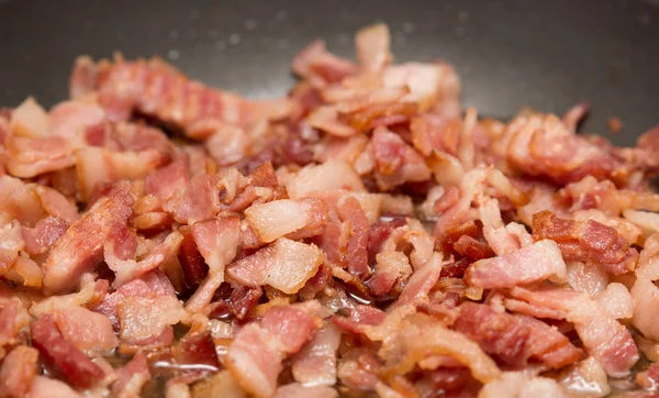Bacon frying in pan — Stock Photo, Image