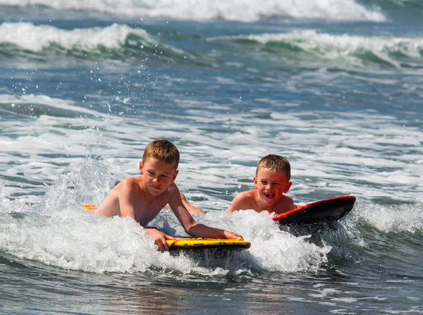 Two boys playing in surf — Stock Photo, Image