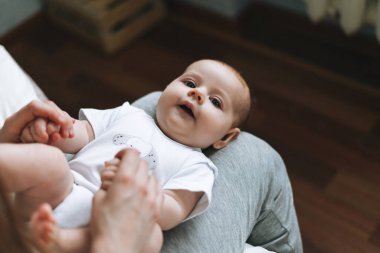 Genç bir anne, dizlerinin üstünde tatlı bir kızla eğleniyor. Evde yatakta oturuyor, duyguları seviyor.