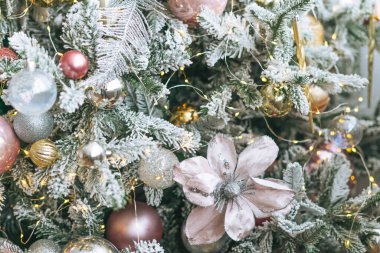 Altın ve beyaz oyuncaklarla süslenmiş Noel ağacı. Işıklar bokeh desenli.
