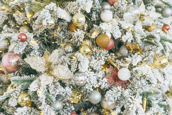 Altın ve beyaz oyuncaklarla süslenmiş Noel ağacı. Işıklar bokeh desenli.