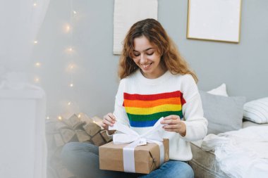 Güzel, mutlu bir genç kız hediye kutusuyla çocuk odasında yatağında.