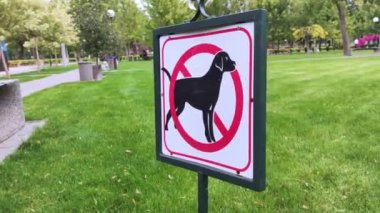 Köpek tabelasına yakın çekim yok. Yeşil çimlerin arka planında sokak işaretçisi. Park çimlerine ve yeşil alanlara dışkılama ve evcil hayvan çalıştırma yasağı. İnsanlar olmadan. Köpekler giremez. Metin için yer