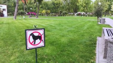 Köpek tabelasına yakın çekim yok. Yeşil çimlerin arka planında sokak işaretçisi. Park çimlerine ve yeşil alanlara dışkılama ve evcil hayvan çalıştırma yasağı. İnsanlar olmadan. Köpekler giremez. Metin için yer
