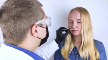 Kız koku kaybı hakkında doktora şikayette bulunuyor. Doktor bir koku testi uygular. Covid-19 teşhisi. Koronavirüsün belirtileri. Karantina ve tecrit. Sars-cov-2 için test