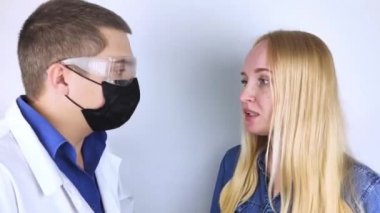Kız koku kaybı hakkında doktora şikayette bulunuyor. Doktor bir koku testi uygular. Covid-19 teşhisi. Koronavirüsün belirtileri. Karantina ve tecrit. Sars-cov-2 için test