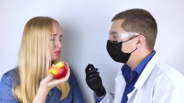患者は味の損失について医者に不平を言う セラピストのフロントの女の子は食べ物をしようとし 健康労働者はテストを分析します Covid19症状 保護マスク ゴーグル — ストック動画