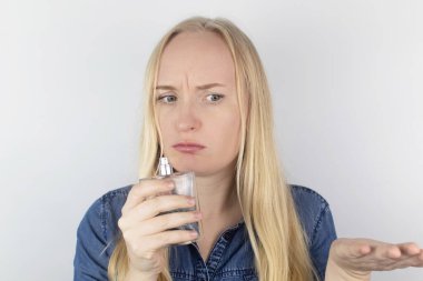 Koku kaybı. Aynanın önündeki kız parfümü kokluyor ve hissetmediğini fark ediyor. Kendi kendine teşhis kovid-19. Koronavirüsün belirtileri. Karantina ve tecrit. Sars-cov-2 için test