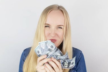 Para koklayan bir kızın yakın çekimi. Para biriminden delilik ve açgözlülük. Yolsuzluk kavramı ve ne pahasına olursa olsun para kazanmak. Sıkıştır ve bize dolar at. Kâr için vahşi bir açlık