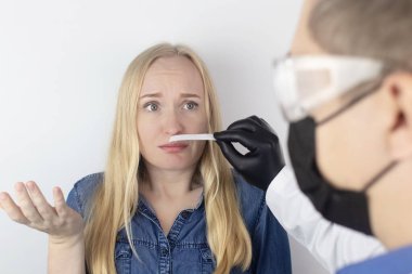 Kız koku kaybı hakkında doktora şikayette bulunuyor. Doktor bir koku testi uygular. Covid-19 teşhisi. Koronavirüsün belirtileri. Karantina ve tecrit. Sars-cov-2 için test
