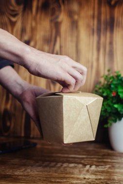 Yemek servisi. Kız elinde hazır yiyeceklerle kese kağıdı tutuyor. Covid 19 'a karşı koyma konsepti. Restorandan ya da kafeden teslimat var. Yemek konteynerleri açılıyor