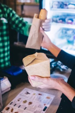 Yemek servisi. Kız elinde hazır yiyeceklerle kese kağıdı tutuyor. Covid 19 'a karşı koyma konsepti. Restorandan ya da kafeden teslimat var. Yemek konteynerleri açılıyor