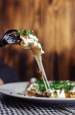 Restoranda tabakta peynirli krep. Kahvaltını kafede yap. Bir kadın kahvaltıda tek kullanımlık yemeklerden krep yer. Üst görünüm ve dikey fotoğraf