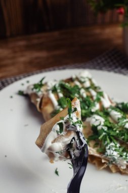 Restoranda tabakta peynirli krep. Kahvaltını kafede yap. Bir kadın kahvaltıda tek kullanımlık yemeklerden krep yer. Üst görünüm ve dikey fotoğraf